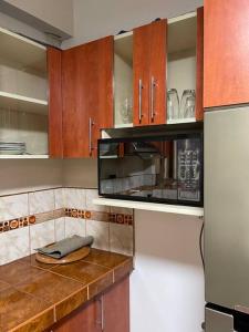 a kitchen with a counter with a microwave and a refrigerator at Apartamento a 10 min del centro de la ciudad in Huaraz