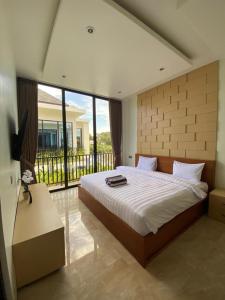 a bedroom with a large bed and a balcony at EL Suites Berawa - Canggu in Canggu +264 photos