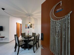 a dining room with a black table and chairs at Lua de Sossego - 3 quartos com Ar na praia dos milionários in Ilhéus