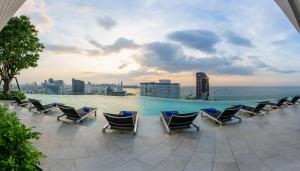 a group of chairs sitting on top of a swimming pool at Somerset Pattaya - SHA Plus in Pattaya