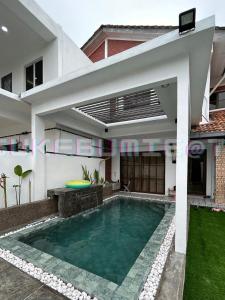 a house with a swimming pool in front of it at sukebumie7 in Shah Alam