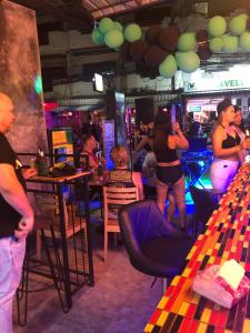 een groep mensen die in een bar staan bij The Green Spot in Pattaya