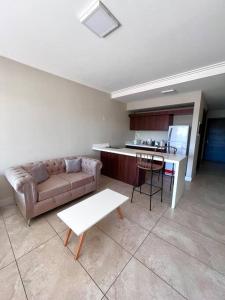 布宜諾斯艾利斯的住宿－Hermoso depto con amenities en Belgrano，带沙发和桌子的客厅以及厨房。