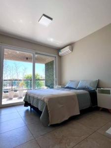 a bedroom with a large bed and a large window at Hermoso depto con amenities en Belgrano in Buenos Aires