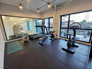 a gym with cardio equipment in a room with windows at ABC@48 Hotel & Service Apartment in Bangkok