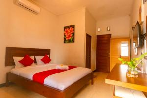 een slaapkamer met een groot bed met rode kussens bij Kost & Homestay 911 in Mataram