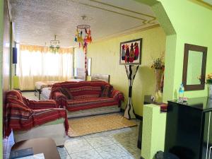 a living room with two couches and a tv at Hostal y Complejo Recreacional La Playita de Monse in Otavalo