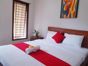 een slaapkamer met een bed met een rode en witte deken bij Kost & Homestay 911 in Mataram