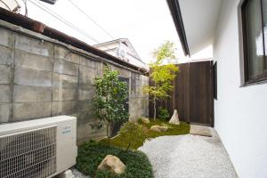 - un petit jardin sur le côté d'une maison dans l'établissement ゲストハウス京都ミルズ紅藤庵, à Kyoto