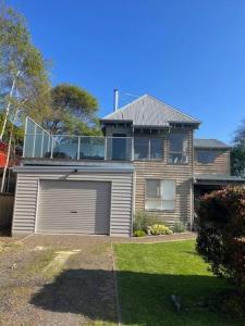 a large house with a garage in front of it at Apollo Bay Rocket House l Pet-Friendly Free Wi-Fi in Apollo Bay