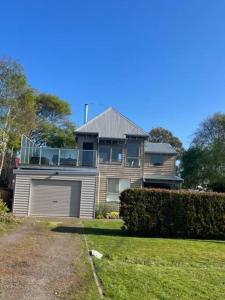 a large house with a garage in the yard at Apollo Bay Rocket House l Pet-Friendly Free Wi-Fi in Apollo Bay
