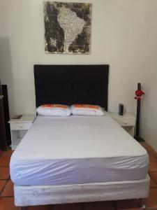 1 cama con 2 almohadas en una habitación en Camunda, en Punta del Este