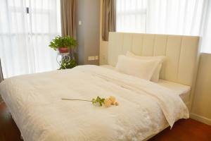 ein Schlafzimmer mit einem weißen Bett mit Blumen darauf in der Unterkunft 悠闲的时光 in Changsha