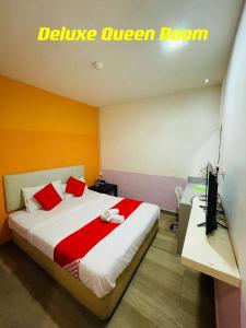 1 dormitorio con 1 cama con almohadas rojas y TV en City Kuchai Hotel -Kuchai Lama,Kuala Lumpur, en Kuala Lumpur