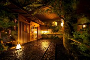 京都市にあるKyoto Arashiyama Onsen Ryokan Togetsuteiの夜間の照明付きの中庭のある建物