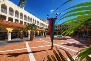 a courtyard of a building with a palm tree at Portobello Palmanova, Palmas del Mar, Humacao, PR in Humacao