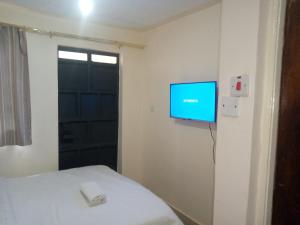 a room with a bed and a tv on the wall at The pinnacle in Kikuyu