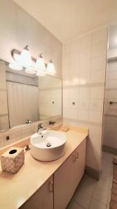 a bathroom with a sink and a mirror at Portobello Palmanova, Palmas del Mar, Humacao, PR in Humacao