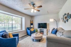 a living room with blue furniture and a ceiling fan at Mpressive Hideaway! in Grand Prairie