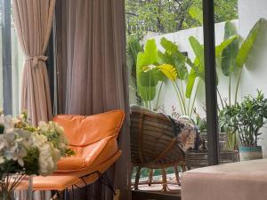 Camera dotata di balcone con sedia e piante. di Holi Cheerful Pool Villa a Nha Trang