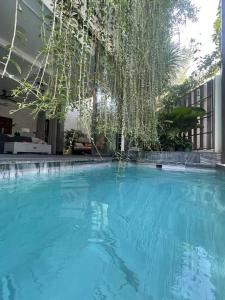 una grande piscina con un albero appeso sopra di Holi Cheerful Pool Villa a Nha Trang