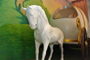 a white plastic horse standing next to a toy car at Hi Kids B&B in Zhixue