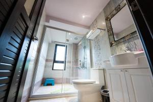 a bathroom with a shower and a toilet and a sink at Hi Kids B&B in Zhixue