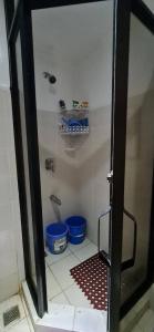 a shower with two blue buckets in a bathroom at San Remo Oasis in Cebu City