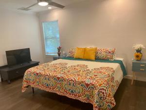 a bedroom with a bed and a flat screen tv at Alamo City Haven in San Antonio