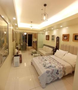 a bedroom with a bed and a living room at Breezy Nest Staycation at Wind Residences Tagaytay in Tagaytay