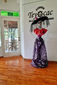 una estatua de una mujer con un paraguas en una habitación en Posada Teyecac, en San Juan Teotihuacán
