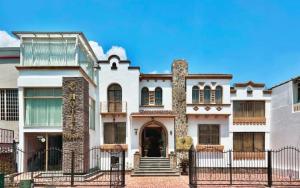 a large house with a gate in front of it at Dakani Hotel Boutique NEW in Quito