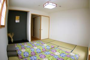 a bedroom with a bed with a colorful bedspread at Vegan Minshuku Sanbiki Neko in Kyoto