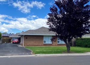 a house with a tree on the side of a street at Rosa's Apartment in Mount Gambier