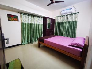 um quarto com uma cama roxa e cortinas verdes em J2 Home Stay - Luxury Homes with Caravan Services em Trivandrum