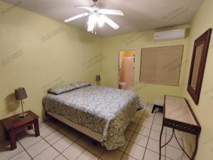聖卡洛斯的住宿－Casa Villa Serena 5, enfrente de la alberca!，一间卧室配有一张床和吊扇
