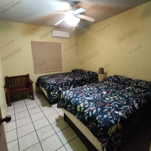 una camera da letto con due letti e un ventilatore a soffitto di Casa Villa Serena 5, enfrente de la alberca! a San Carlos Altre 5 foto