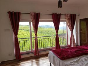 a bedroom with a large window with a view at Tea Estate view stay in Ooty