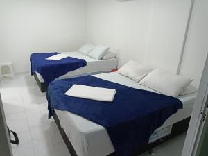 two beds in a room with blue and white at apartamento duplex Arraial do Cabo VISTA PARA MAR in Arraial do Cabo