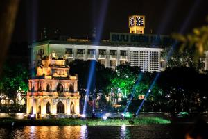 a fountain in front of a building at night at Hanoi Luxury Hotel in Hanoi