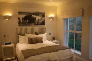 Plett Luxury Home في بليتنبيرغ باي: غرفة نوم بسرير وصورة فيلة