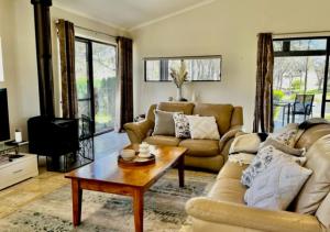 a living room with a couch and a coffee table at Granite Gardens Cottages & Lake Retreat in Stanthorpe