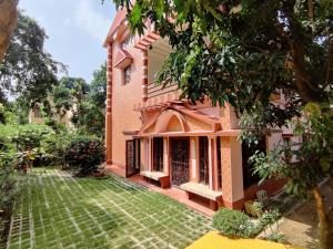 an exterior view of a house with a yard at Abode of Peace in Bolpur