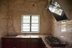 a kitchen with a stove and a sink and a window at Abode of Peace in Bolpur