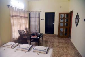 a bedroom with a bed and a table with chairs at Abode of Peace in Bolpur