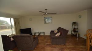 a living room with two chairs and a tv at Unit 2 5 Pilot St Yamba in Yamba