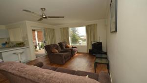 a living room with two couches and a television at Unit 2 5 Pilot St Yamba in Yamba