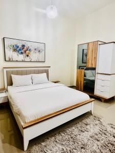 a bedroom with a large bed and a dresser at Abu Rakan Apartment in Muscat