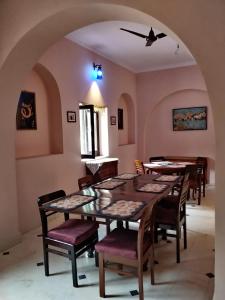 a dining room with tables and chairs and an archway at Sankhu Niwas in Bikaner