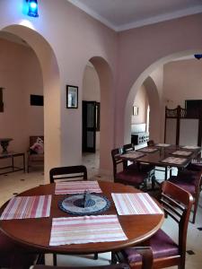 una sala da pranzo con tavoli, sedie e archi di Sankhu Niwas a Bikaner